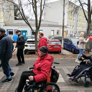 Uczestnicy ŚDS oraz mieszkańcy Swarzędza, w tym dwie osoby poruszające się za pomocą wózka, biorą udział w marszu