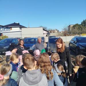 Uczestnicy ŚDS, przedszkolaki oraz instruktorzy rozmawiają pomiędzy skrzyniami uprawnymi